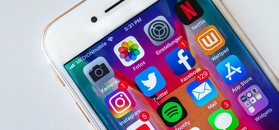 Image of an iPhone showing apps like Instagram, Twitter, and Facebook